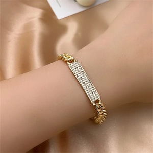 Macro detail of gold Cuban link bracelet with micro-paved sparkling diamond plate