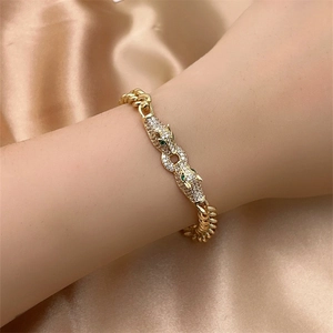 Detail of gold Cuban chain bracelet with leopard heads set in pavé white cubic zirconia