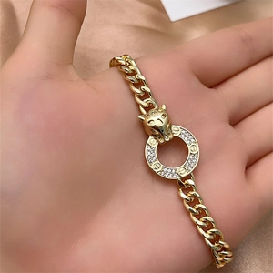 Close-up of golden Cuban chain bracelet with leopard head clasp and diamond ring