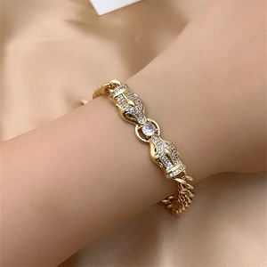 Detail of luxury gold panther head bracelet with sparkling crystals on satin background