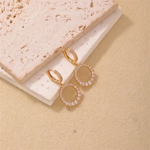 Boucles d'oreilles créoles ovales dorées avec zircons étincelants sur support en pierre