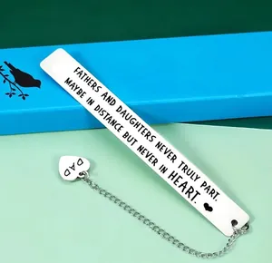 Close-up of stainless steel bookmark with engraved quote and a heart pendant for dad