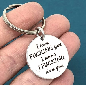Macro shot of stainless steel keychain with humorous engraved text for couples