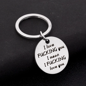 Close-up of stainless steel keychain with engraved romantic quote for couples