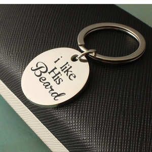 Macro detail of His Beard engraved phrase on a brushed stainless steel round keychain