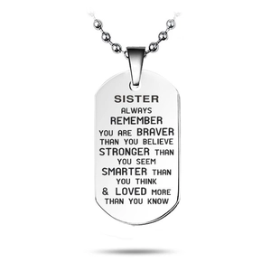 Macro detail of engraved inspirational quote on polished stainless steel dog tag necklace