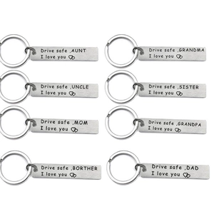 Eight rectangular stainless steel keyrings with drive safe family engravings on white background