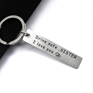 Detailed view of Drive safe SISTER engraving on silver stainless steel keychain pendant