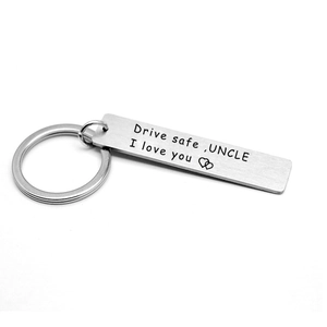 Macro detail of Drive Safe Uncle engraved stainless steel keychain with heart design