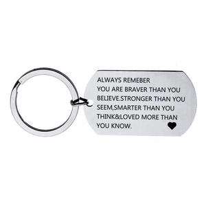 Macro detail of engraved stainless steel dog tag keychain with motivational quote and heart