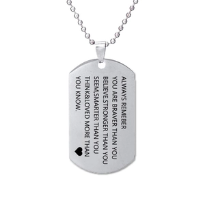 Macro view of brushed stainless steel dog tag with engraved inspirational quote and heart