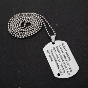 Inspirational stainless steel dog tag necklace with engraved quote on black background