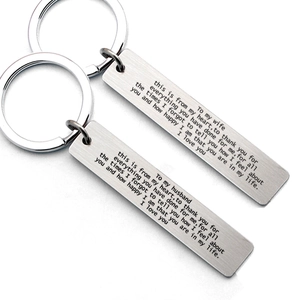Macro detail of brushed stainless steel rectangle keychains with romantic engravings