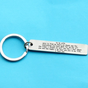 Polished stainless steel keychain with engraved message for spouse on blue texture