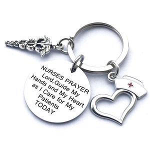 Macro detail of stainless steel nurse prayer keychain with medical caduceus and heart charms