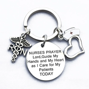 Detail of silver nurse keychain featuring medical CAD symbol and RN prayer charm