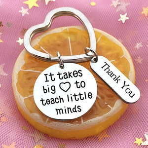 Macro view of stainless steel heart keychain with 'It takes big heart' teacher message