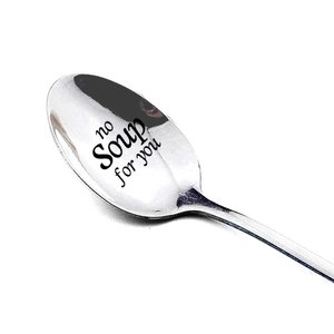 Détail d'une cuillère en acier poli avec l'inscription humoristique no Soup for you gravée