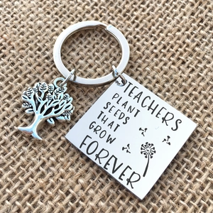 Stainless steel teacher keychain with tree of life charm on a rustic burlap background
