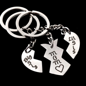 Dettaglio del portachiavi puzzle a cuore in tre pezzi con incisioni Mom e Sis