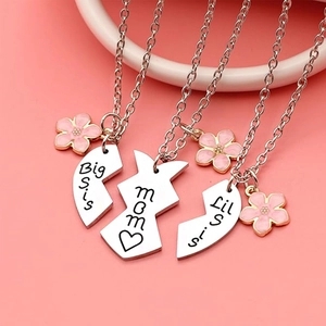 Macro dei tre pezzi di collane di famiglia a cuore con incisione per mamma e sorelle