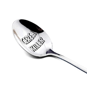 Macro shot of polished stainless steel spoon engraved with Cereal Killer text