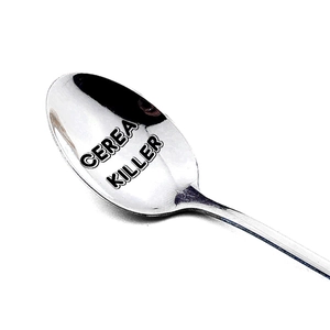 Close-up of a silver stainless steel spoon with Cereal Killer engraved text detail