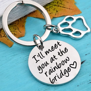 Rainbow bridge pet memorial keychain with paw charm and heart engraving on blue wood