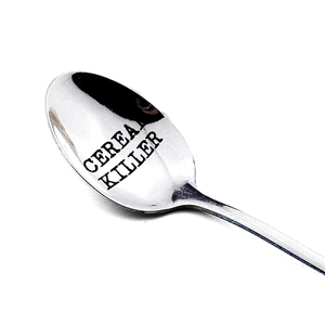 Polished stainless steel spoon with Cereal Killer engraved text on white background