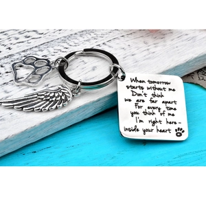 Detail of pet memorial keychain with engraved poem charm, feather and paw print charms
