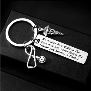 Detail of silver stainless steel keychain featuring a medical caduceus and stethoscope