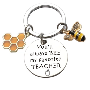 Macro detail of stainless steel bee keychain with engraved teacher appreciation message