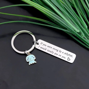 Cute jellyfish keychain with engraved rectangular metal tag on a black background