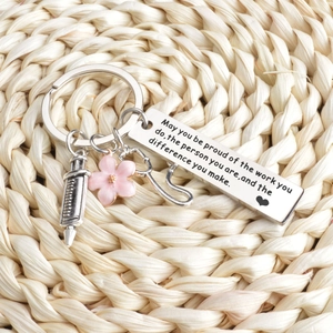 Macro view of medical keychain with stethoscope syringe and flower charms on woven mat