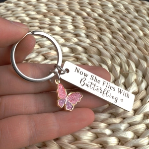 Macro view of stainless steel memorial keychain with butterfly charm and engraved text