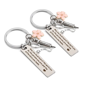 Detail of medical keychain with stethoscope syringe charms and engraved quote