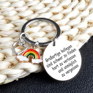 Macro detail of stainless steel keychain with rainbow heart and German engraved charm