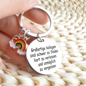 Detail of stainless steel keychain with rainbow charm and German colleague quote engraving