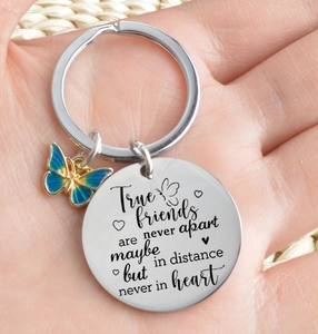 Detail of friendship stainless steel keychain with engraved quote and blue butterfly charm