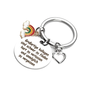 Detail of stainless steel keychain with German engraving, heart charm and rainbow pendant