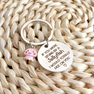 Stainless steel jellyfish keychain with engraved humor text on a woven background