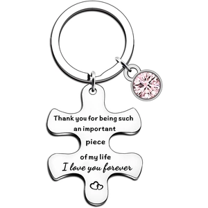 Detail view of engraved puzzle piece keychain with a pink crystal and heart pattern