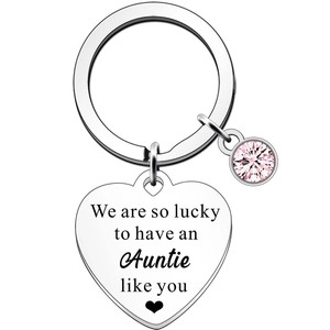 Detail of heart keychain with Auntie quote and pink gemstone on white background