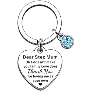 Detailed close-up of heart-shaped stainless steel keychain with blue gem and engraving