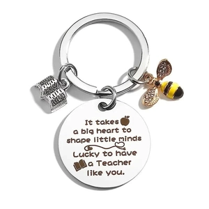 Macro view of teacher keychain with engraved message and small bee charm detail
