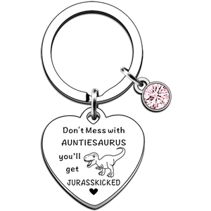 Macro shot of heart-shaped stainless steel keychain with dinosaur engraving and pink gemstone