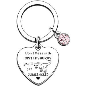 Macro detail of silver heart keychain with humorous Sistersaurus quote and pink rhinestone