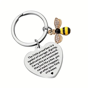 Detail of bee keychain with engraved heart tag and crystal wings on white background