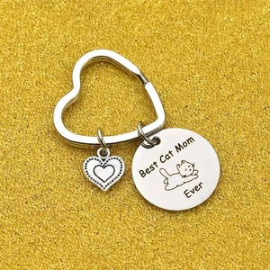 Silver stainless steel Best Cat Mom Ever keychain with heart charm on gold glitter background