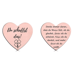 Detail view of heart-shaped rose gold lucky coins with clover engraving and German quote
